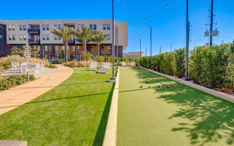a building with a green lawn and four colorful balls on the ground