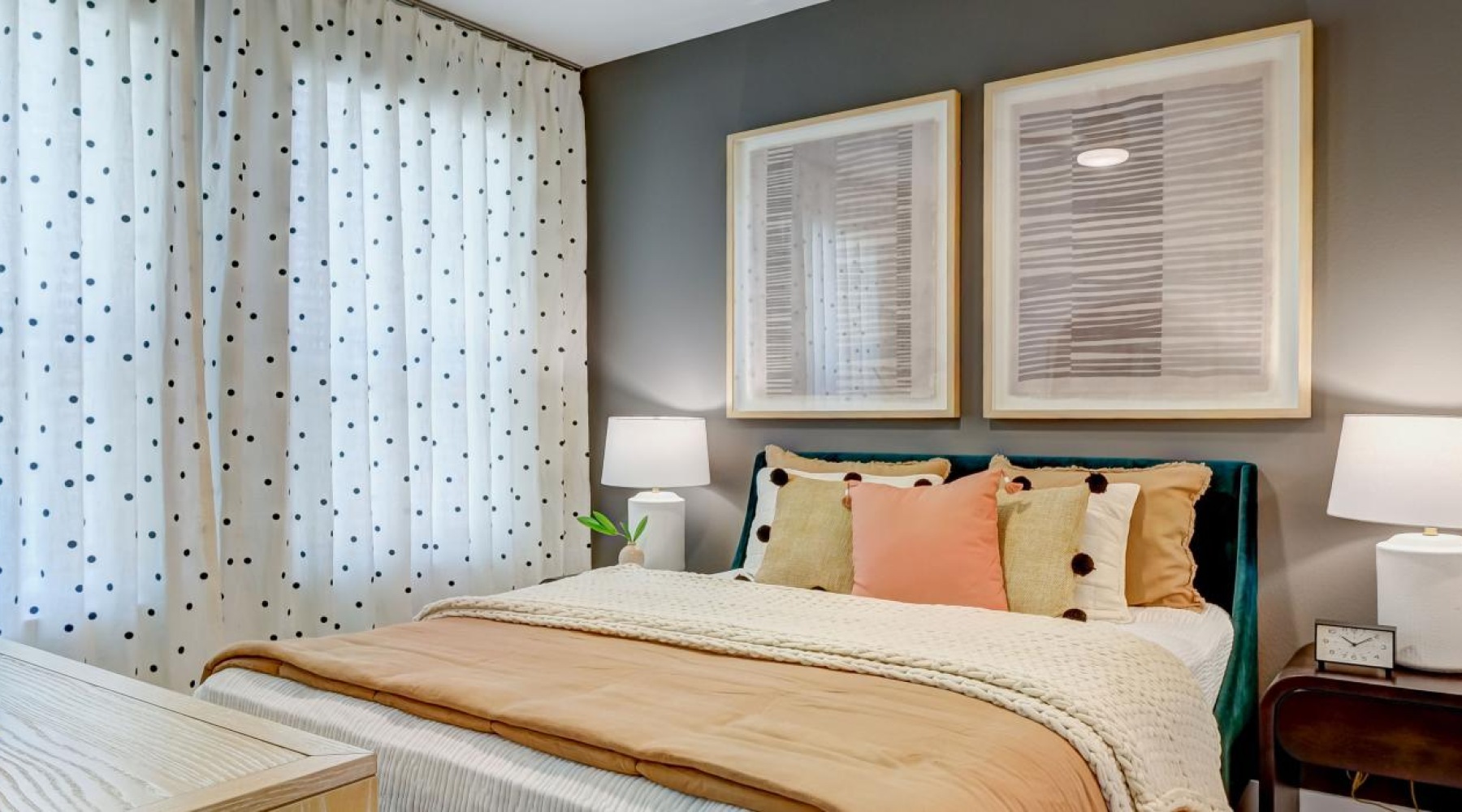 a bedroom with a nightstand, dresser and a window