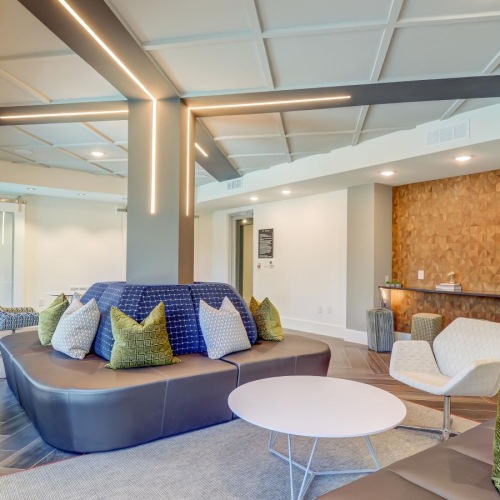 a lounge area with a couch and chairs