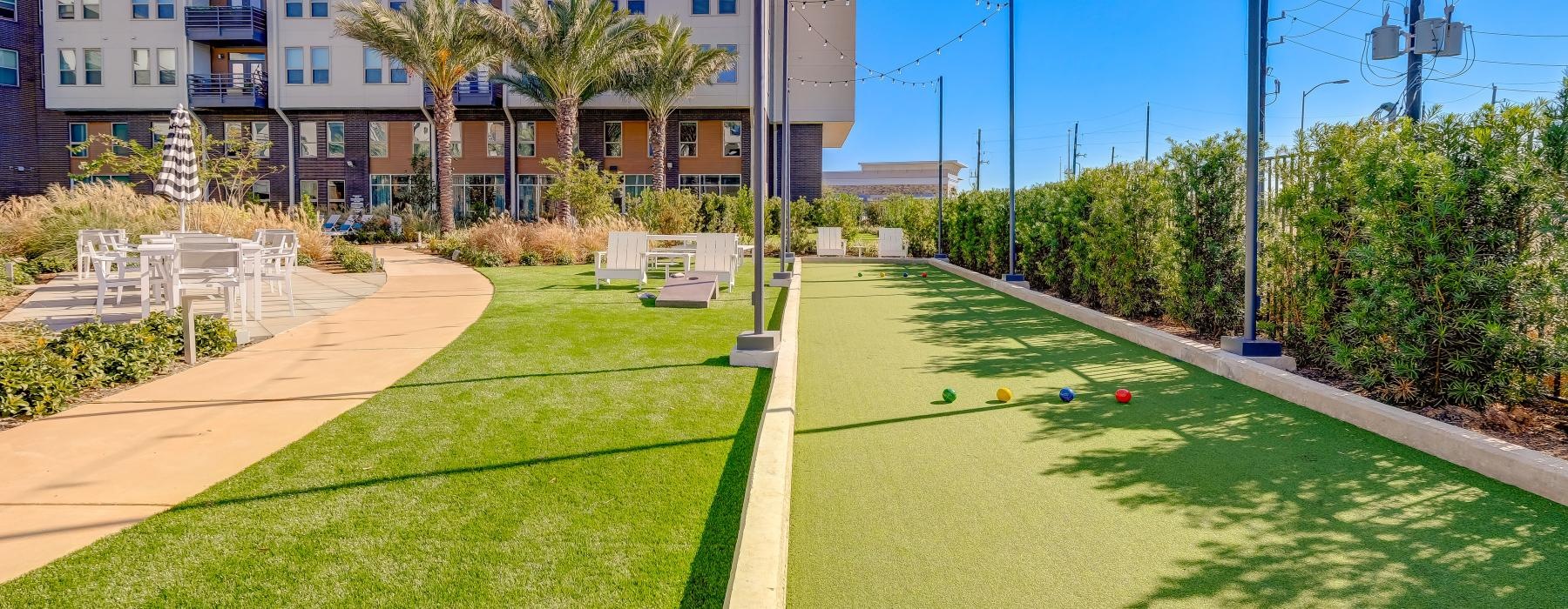 a building with a green lawn and four colorful balls on the ground