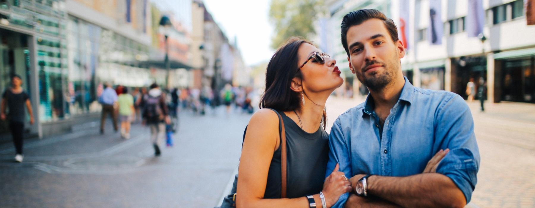 a man and woman posing for a picture on a street
